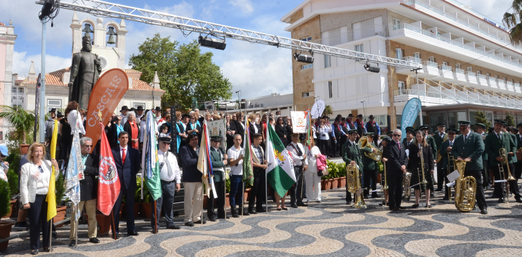 150 vozes e seis bandas interpretam o Hino Nacional enquanto é hasteada a bandeira