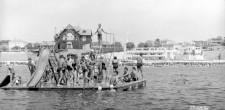 Banhistas em plataforma de mergulho, junto à Praia da Duquesa, em Cascais. Ao fundo, Casa Faial e Palm Beach, c. 1950